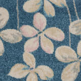 Close-up of Nourison Tranquil Turquoise rug, showing floral pattern in aqua, beige, and pink hues. Soft, textured weave.
