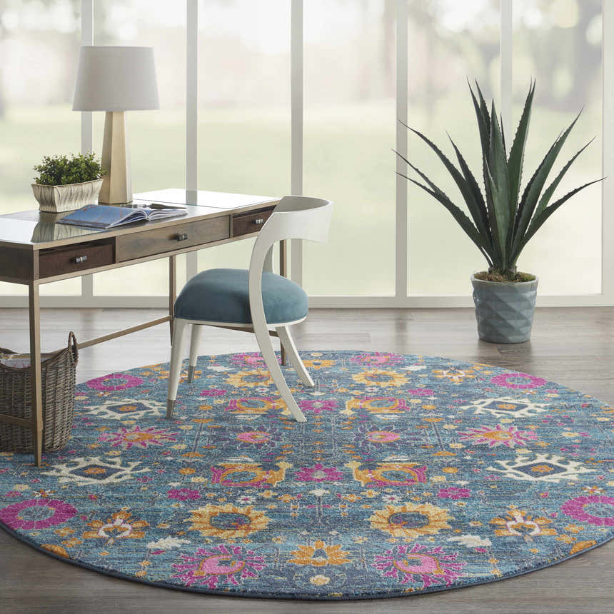 Bright home office with a round Nourison Passion Denim rug, desk, chair, and large window.