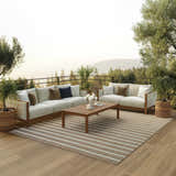 Outdoor patio scene with sofas and Nourison Positano Jute Ivory rug, chestnut stripes, mid-century modern style.