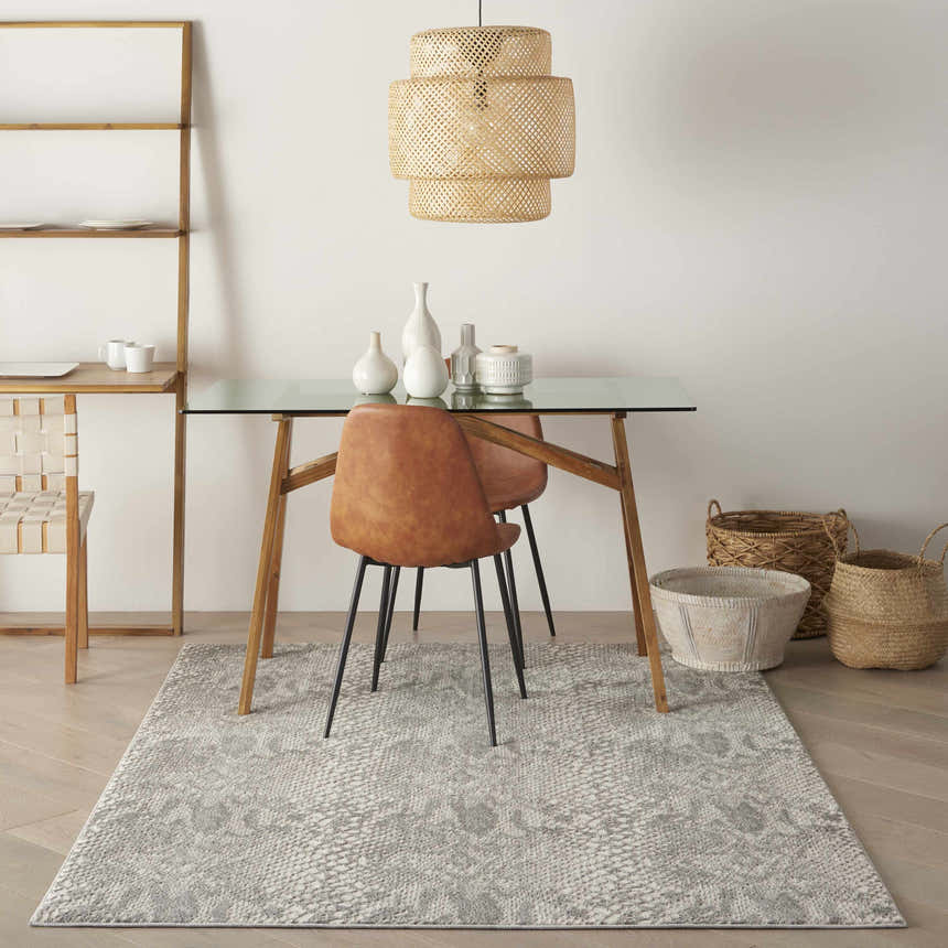 Dining room with glass table, leather chairs, and Nourison Solace Ivory/Grey rug. Modern, neutral aesthetic.