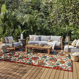 Outdoor patio with gray furniture and Nourison Aloha Red Multicolor Farmhouse Area Rug with floral pattern.