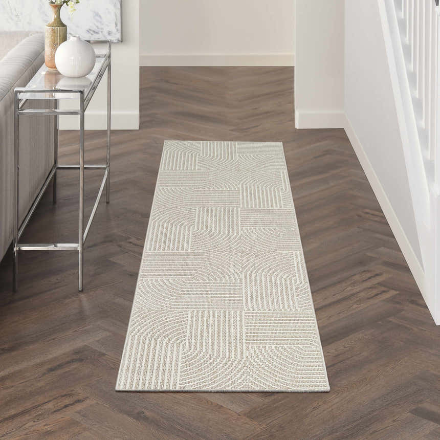 Hallway scene with Nourison Natural Texture beige ivory rug, wood floors, console table, and neutral decor.