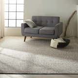 Modern living room with a gray sofa and the Calvin Klein Home Lowland Basalt area rug.