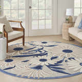 Sunroom with a round Nourison Aloha Blue Grey Outdoor Area Rug featuring a blue and beige floral pattern.