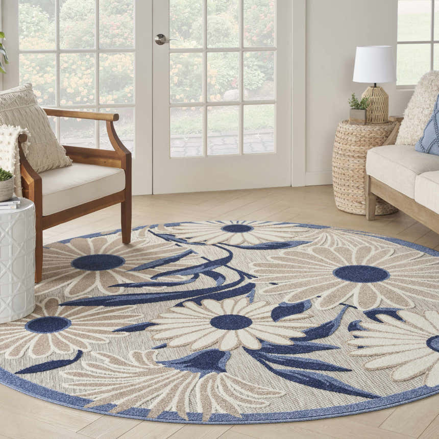 Sunroom with a round Nourison Aloha Blue Grey Outdoor Area Rug featuring a blue and beige floral pattern.