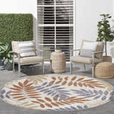 Outdoor patio scene with a Nourison Aloha Blue Mocha oval rug, chairs, and plants.