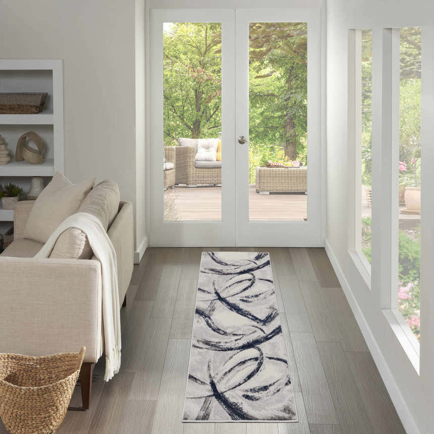 Entryway with Nourison Splash Grey Navy rug runner, light wood floors, beige sofa, and bright outdoor view.