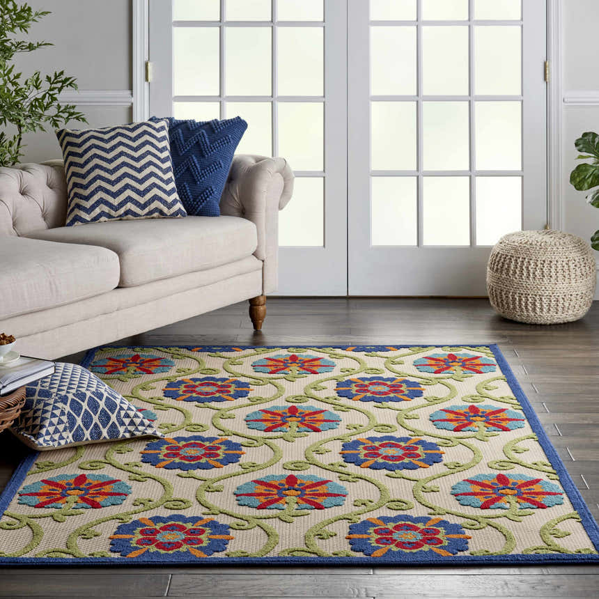 Living room scene with a Nourison Aloha Blue Multicolor rug, beige sofa, and blue pillows.