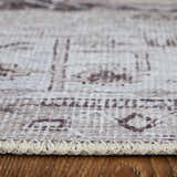 Close-up of the tan, ivory, and gray Feizy Percy rug showing the medallion pattern and braided edge detail. Pile