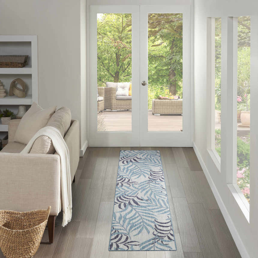Hallway with Nourison Garden Oasis Blue Tropical runner rug, light wood floors, and patio view.