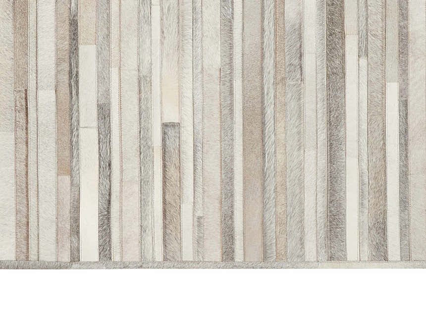 Close-up of the Calvin Klein Home Prairie Silver Area Rug. Features a vertical stripe pattern in shades of gray and cream.