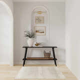 Entryway with black console table and Nourison Astra Sage Bohemian rug on light wood floor.