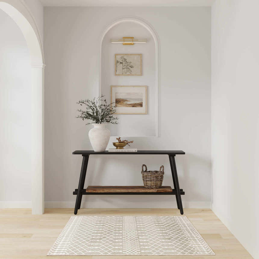 Entryway with black console table and Nourison Astra Sage Bohemian rug on light wood floor.