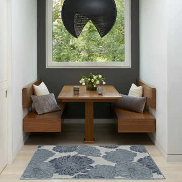 Breakfast nook with wood benches and Nourison Garden Oasis Blue Tropical Area Rug.