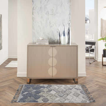 Modern entryway with a grey slate Nourison Paxton rug, wood floors, and minimalist decor.