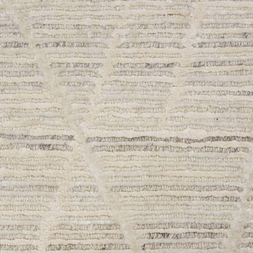 Close-up of the handmade Nourison OCEAN Pearl Rug. Features a textured, mid-century modern design in pearl and gray tones.