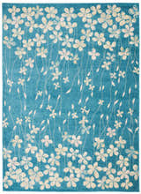 Close-up of the Nourison Tranquil Turquoise rug featuring a floral pattern in cream and aqua on a textured blue background.