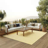 Outdoor patio scene with sofas and Nourison Positano Yellow Ivory rug, creating a modern, inviting space.