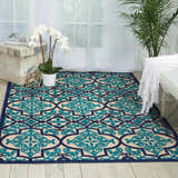Bright living room with a Nourison Aloha Navy Bohemian Area Rug, white furniture, and natural light.