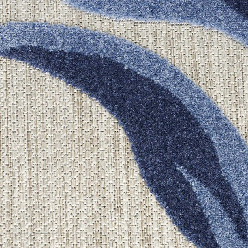 Close-up of the Nourison Aloha Blue Grey Outdoor Area Rug showing blue floral design and textured gray background.