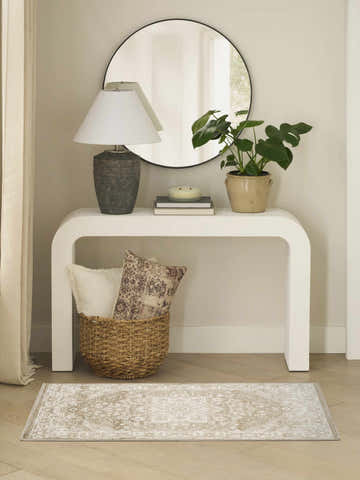 Entryway with white console table, round mirror, and Nourison Dekor Taupe Ivory Vintage Area Rug on wood floor.