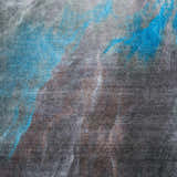 Close-up of Nourison Le Reve rug, charcoal gray with abstract blue and taupe pattern. Mid-century modern style.
