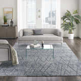 Modern living room with grey sofa, glass table, and Nourison OCEAN Indigo area rug.