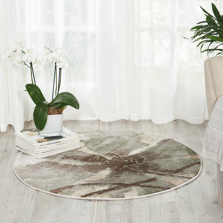 Light and airy room scene with a round Nourison Euphoria Ivory rug featuring chestnut, green, and cream abstract pattern.
