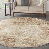 Living room scene with round Nourison Astra Rust Vintage rug, beige sofa, and side table.