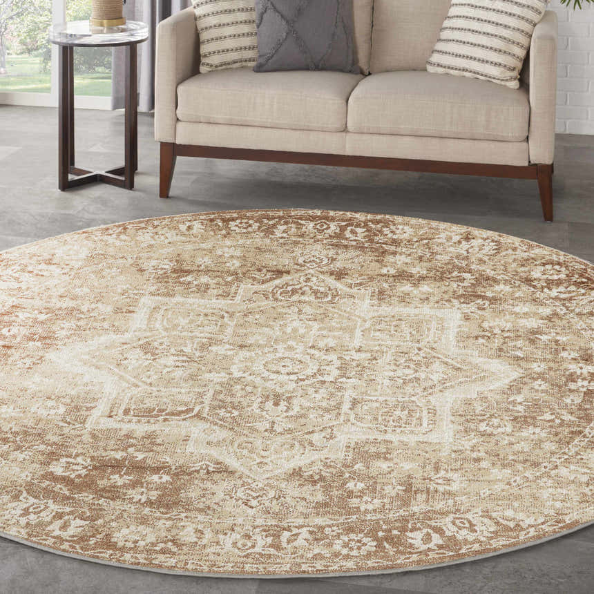 Living room scene with round Nourison Astra Rust Vintage rug, beige sofa, and side table.
