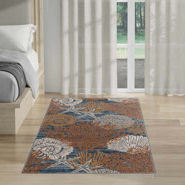 Coastal bedroom with Nourison Seaside Blue Multicolor rug, featuring coral and starfish patterns.