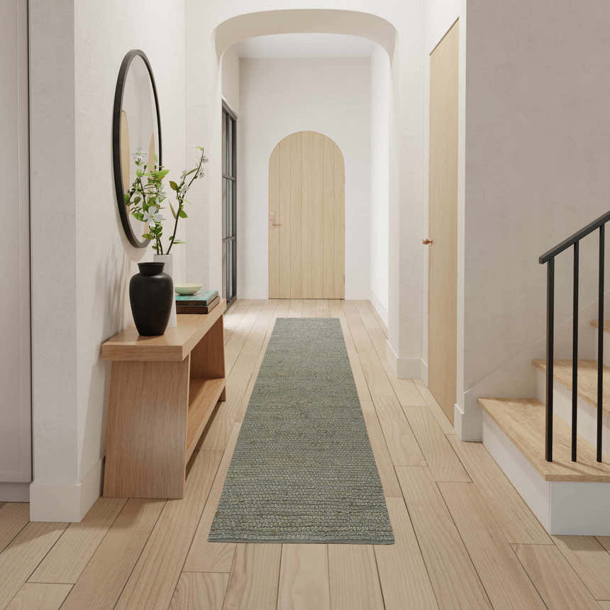 Farmhouse hallway with Nourison Natural Jute Sage runner rug, wood floors, console table, and arched doorway.