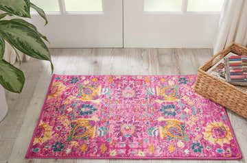 Entryway with bright Nourison Passion Fuchsia rug. Bohemian pattern in fuchsia, blue, and gold on wood floor.
