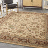 Living room scene with a Nourison Living Treasures Beige rug, leather chair, and gold accent furniture.