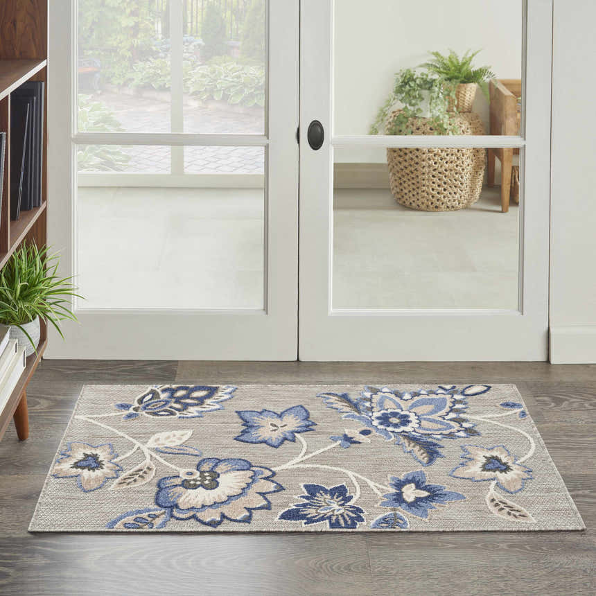 Entryway with Nourison Aloha Blue Grey outdoor rug featuring a floral pattern on a gray background.