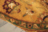 Close-up of the handmade Nourison Jaipur Gold rug. Wool rug features floral design in gold, burgundy, and green tones.