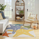 Coastal living room with white sofa and Nourison Aloha Multicolor starfish area rug.