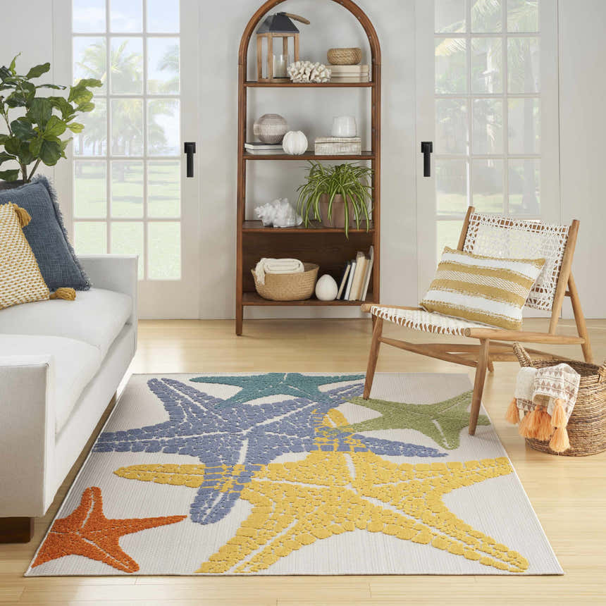 Coastal living room with white sofa and Nourison Aloha Multicolor starfish area rug.