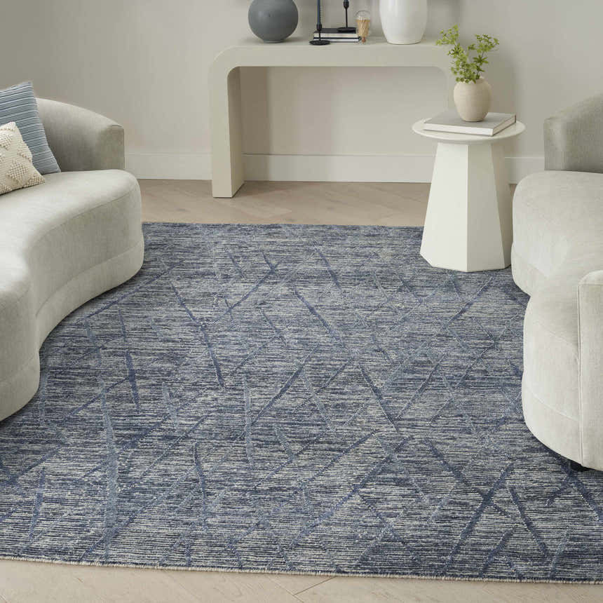 Modern living room with curved sofas and Nourison OCEAN Indigo Area Rug.