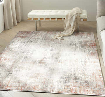 Living room scene with Calvin Klein CK022 Infinity Rust Multicolor rug, white bench, light wood floors, and neutral tones.