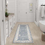 Bathroom scene with a Nourison Astra Blue Vintage runner rug, white cabinets, and light wood floors.