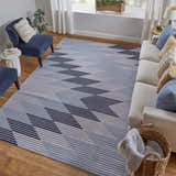 Living room scene with a blue and gray Feizy Marigold geometric rug, sofa, blue chairs, and wood floors. Roomscene-Rectangle