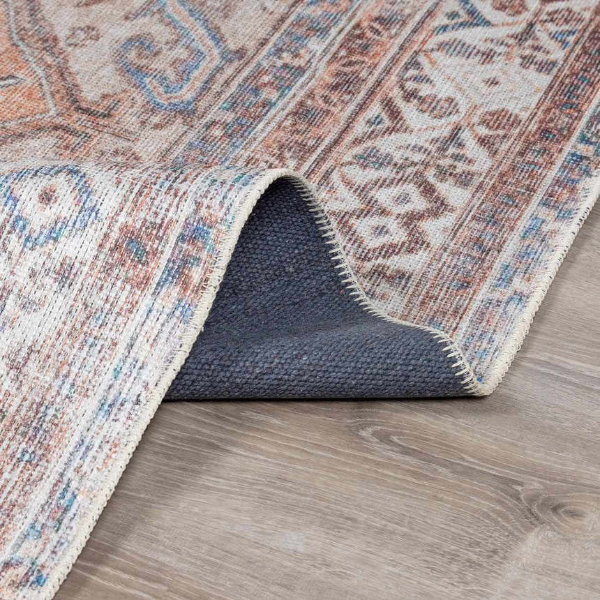 Close-up of Arncliffe Washable Area Rug showing its traditional pattern, colors (brown, blue, orange), and non-slip backing. Fold