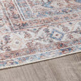 Close-up of the Arncliffe Washable Area Rug showing its light gray, brown, and blue Oriental-style pattern and soft texture. Pile