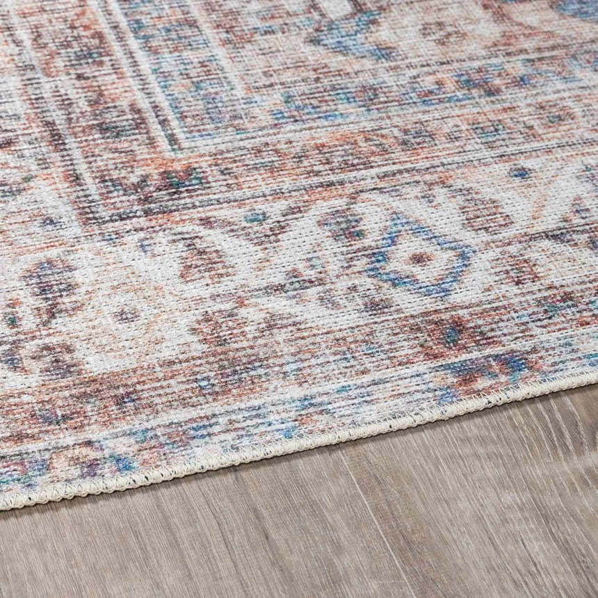 Close-up of the Arncliffe Washable Area Rug showing its light gray, brown, and blue Oriental-style pattern and soft texture. Pile