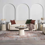 Living room scene with a cream sofa and Arncliffe Washable Area Rug in brown, orange, and gray tones. Bohemian style. Roomscene-Rectangle