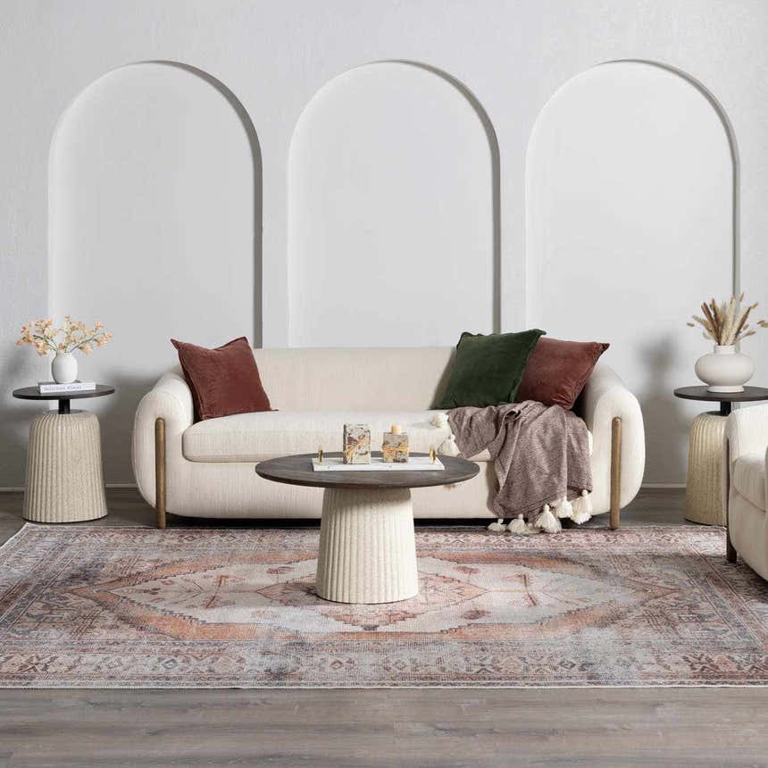 Living room scene with a cream sofa and Arncliffe Washable Area Rug in brown, orange, and gray tones. Bohemian style. Roomscene-Rectangle