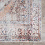 Close-up of the Arncliffe Washable Area Rug. Features an oriental design in brown, orange, ivory, and light blue tones. Swatch