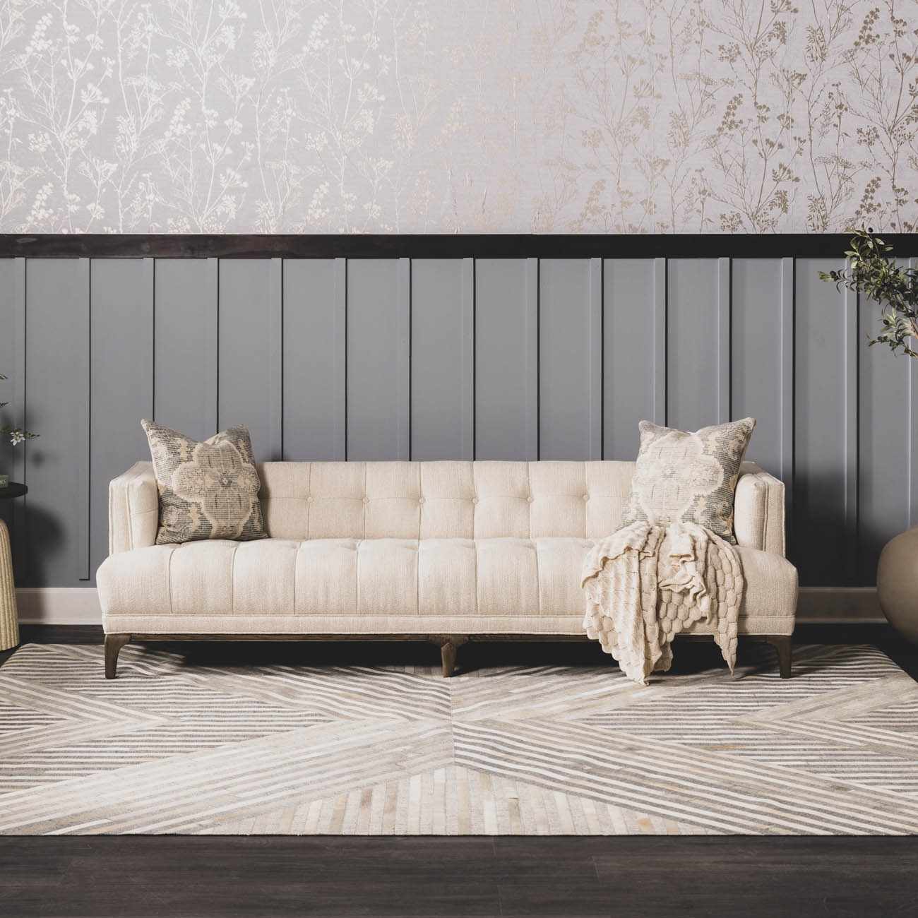 Living room scene with a beige sofa on a geometric Akiye Area Rug in cream, beige, and gray. Roomscene-Rectangle
