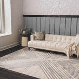 Living room scene with a beige sofa on a geometric Akiye Area Rug in beige, cream, and gray. Roomscene-Rectangle